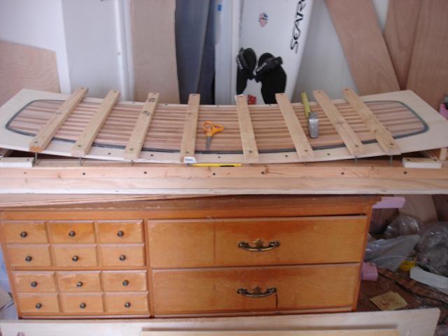 Dry fit to table.  Look how simple that table is -blocks at ends, 3/8 birch ply, some deck screws, a batten under the middle for concave -and it's fair to within 1mm. BTW Strip cores hold rocker well, concave, not so much...